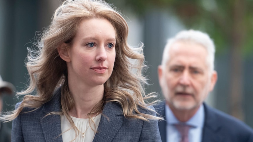 Elizabeth Holmes founder and former CEO of Theranos in a grey suit.