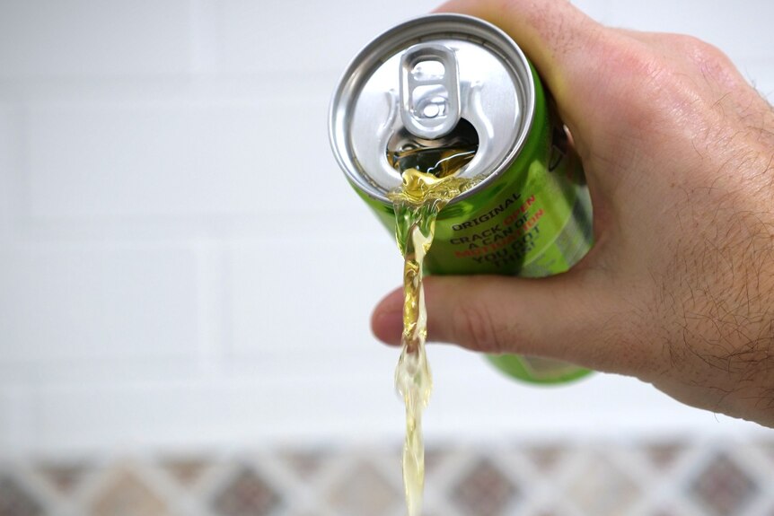 A can of energy drink being poured out.
