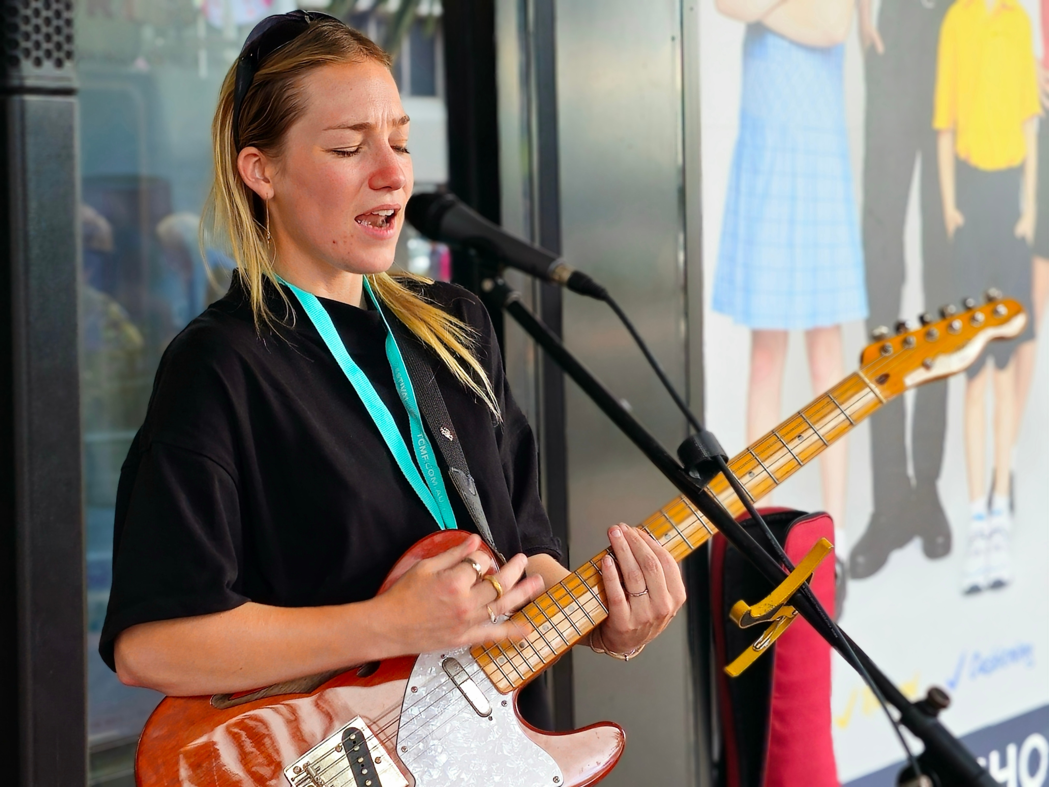 A woman playing an electric guitar and singing