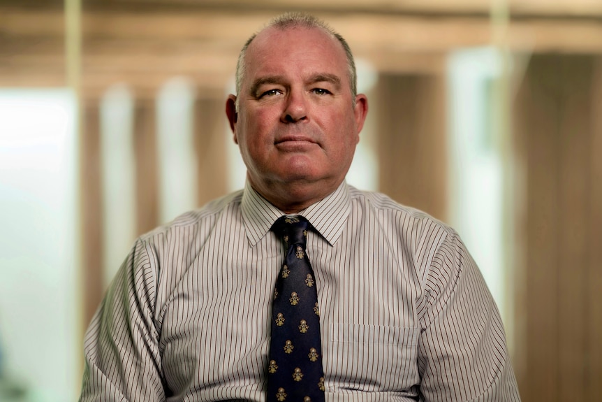 Man wearing a collared shirt and tie.