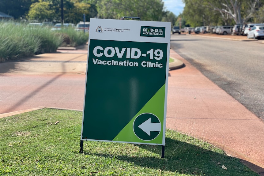Image of a green sign pointing the way to a vaccination centre.