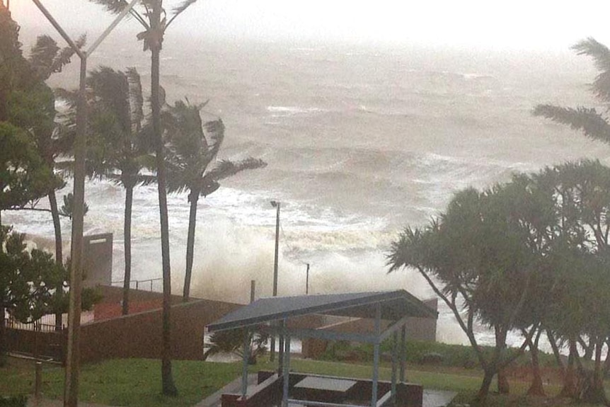 Waves break over Yeppoon seawalls