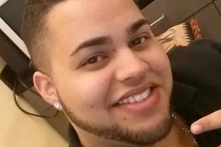 A close-up photo of a young, smiling man.
