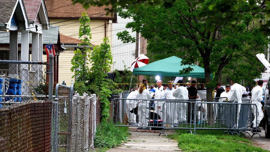 FBI forensic officers gather outside the house where the women were held captive.