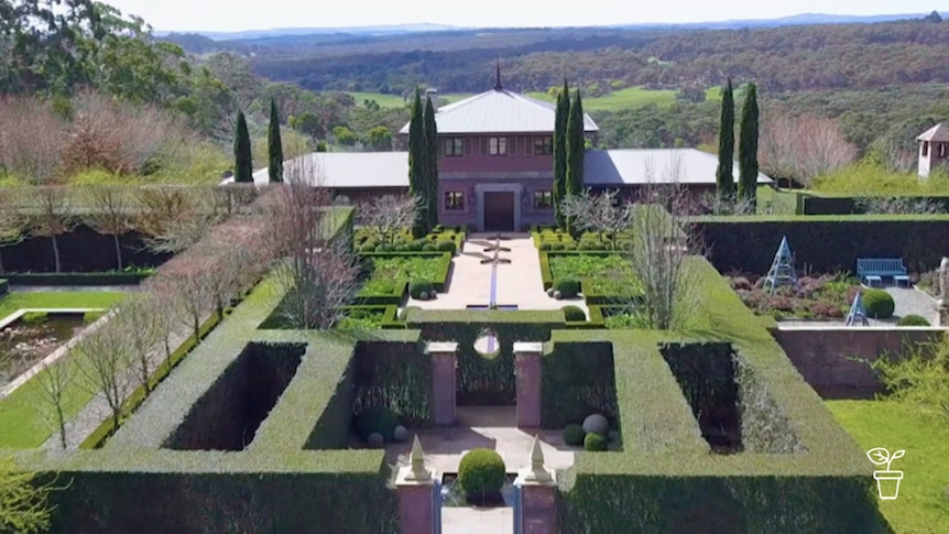 Large house surrounded by grand landscaped formal garden