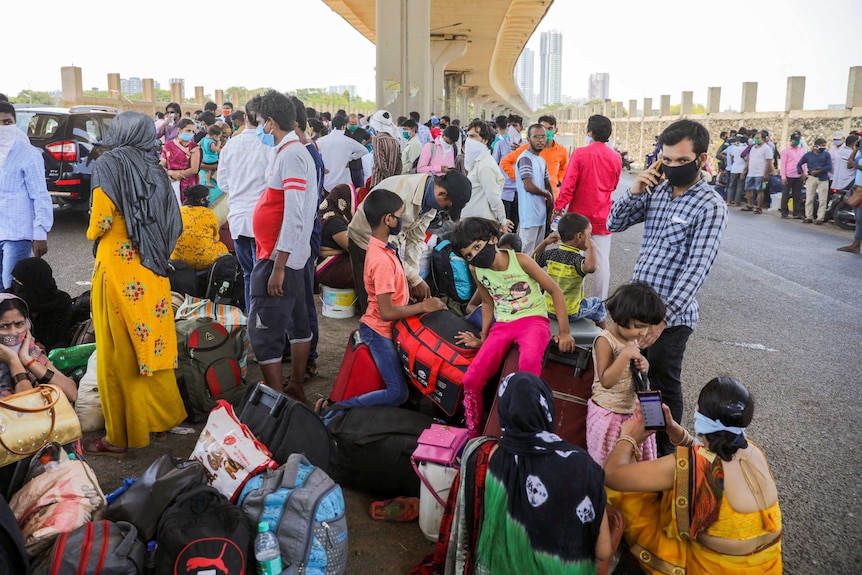 A group of Indian migrants sitting under a bridge