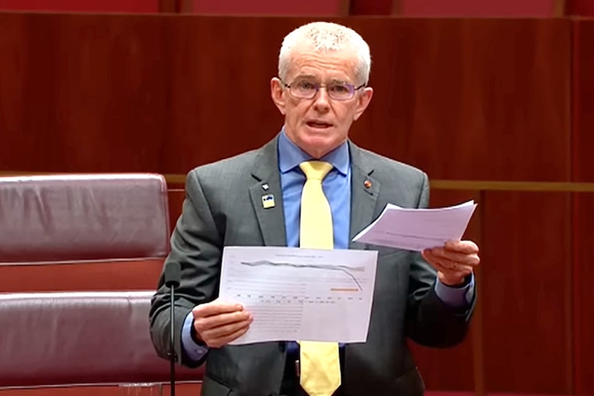 Man with yellow tie holding paper.