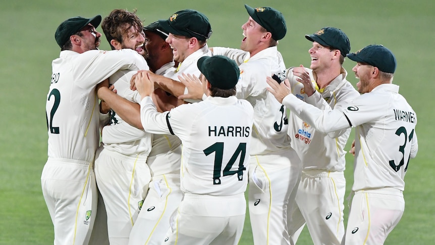 The whole Australian team gathers around Michael Neser to celebrate a wicket with him