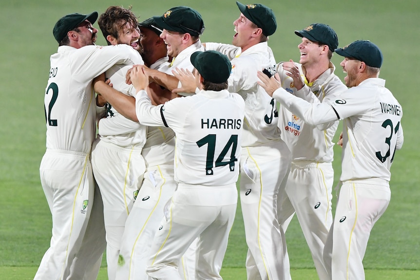 The whole Australian team gathers around Michael Neser to celebrate a wicket with him