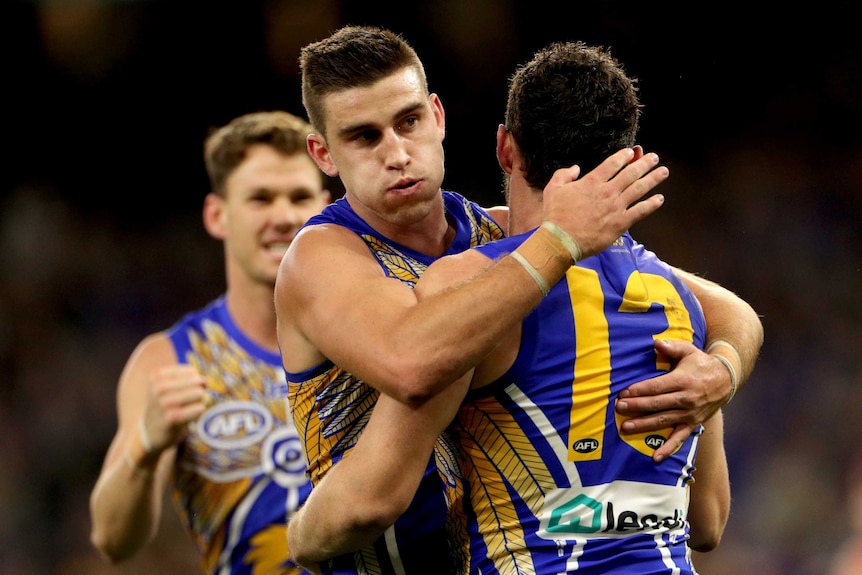 West Coast Eagles midfielder Luke Shuey, with his back turned, is hugged by teammate Elliot Yeo after scoring a goal.