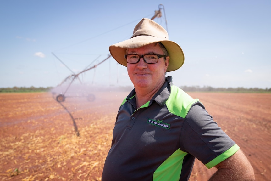 A man wears a hat in a field. 