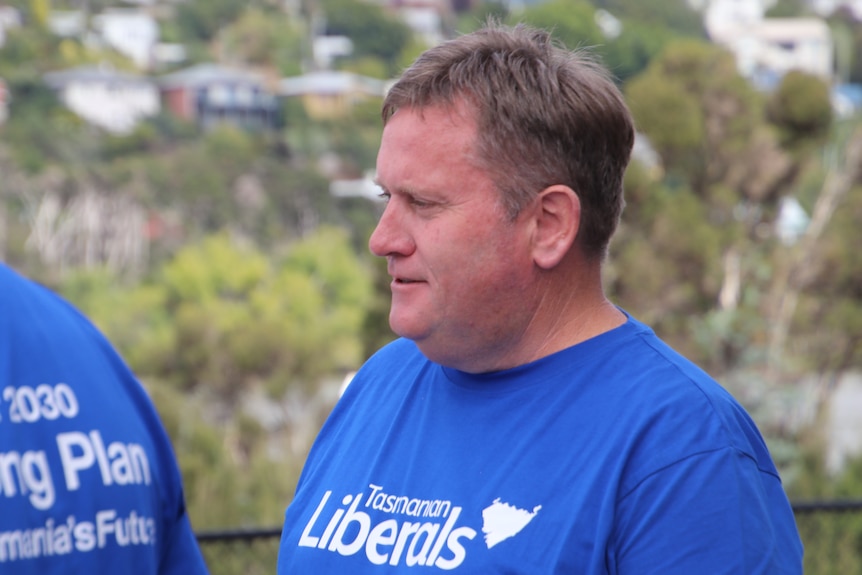 A man wearing a blue t-shirt reading Tasmanian Liberals.