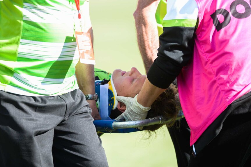A soccer player is taken from the field after getting injured.
