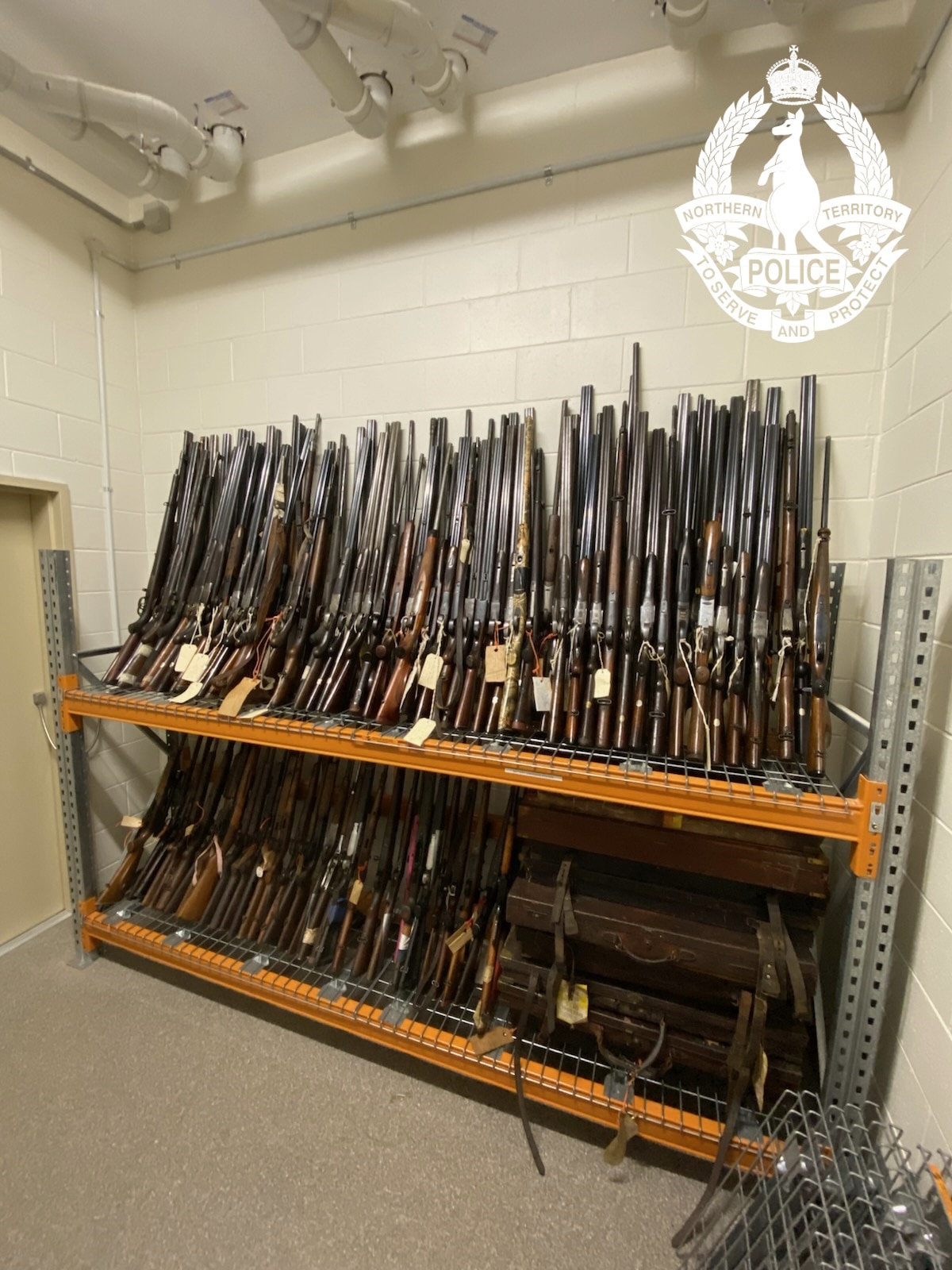 Duas filas de armas alinhadas num armazém.