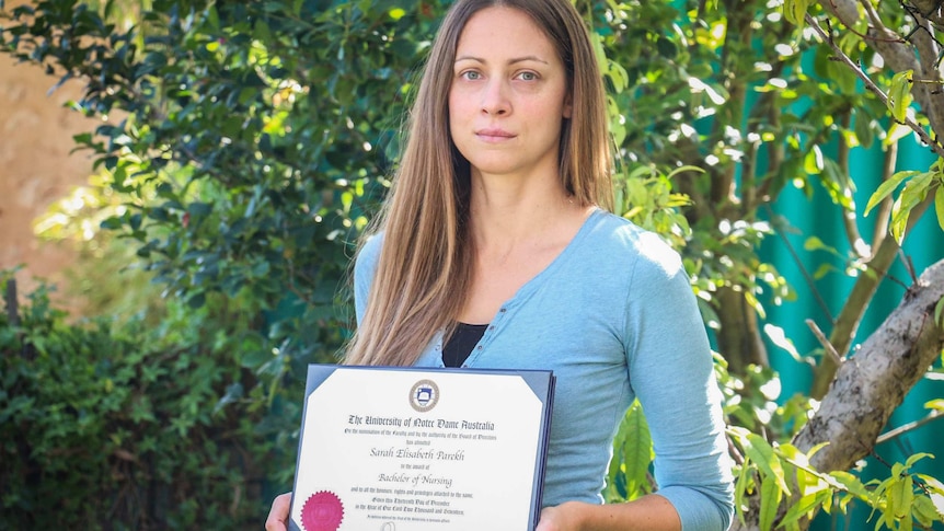 Young woman holding nursing degree