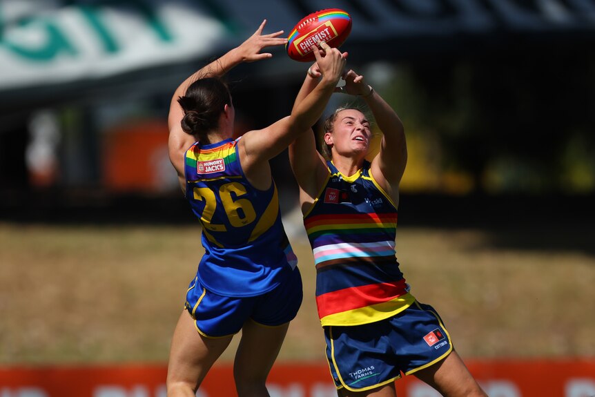 An Eagles AFLW player contests for the ball in the air alongside a Crows opponent.