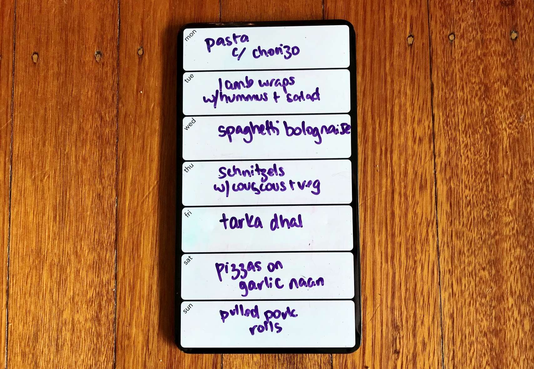 Photograph of a whiteboard divided into days with one meal listed per day.
