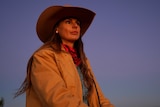 A woman in a cowboy hat on a horse.