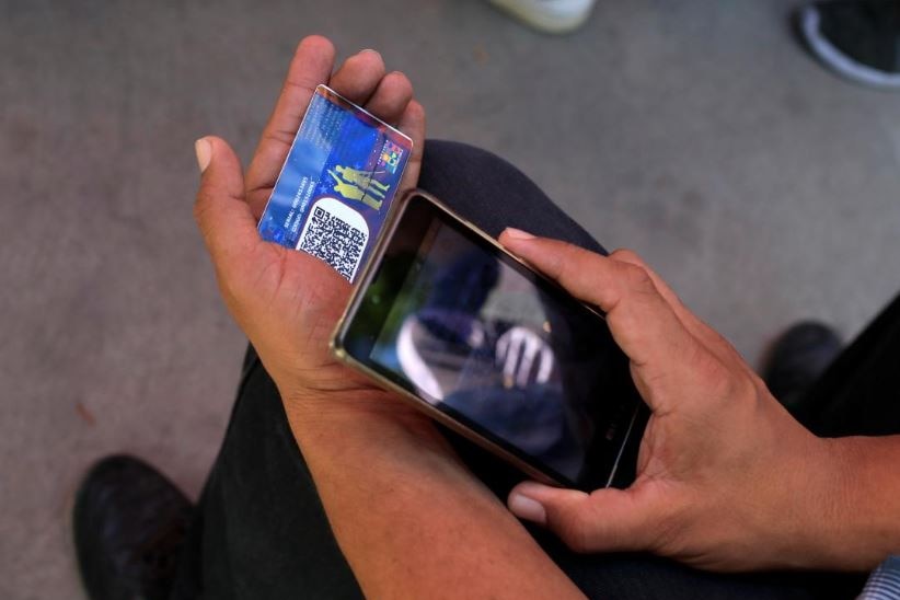 A card QR code is scanned by a man with a mobile phone