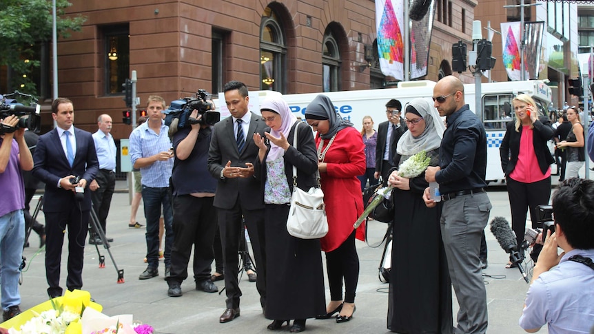 Muslim community leaders pray for the victims of the Sydney siege after laying flowers in Martin Place, December 16 2014