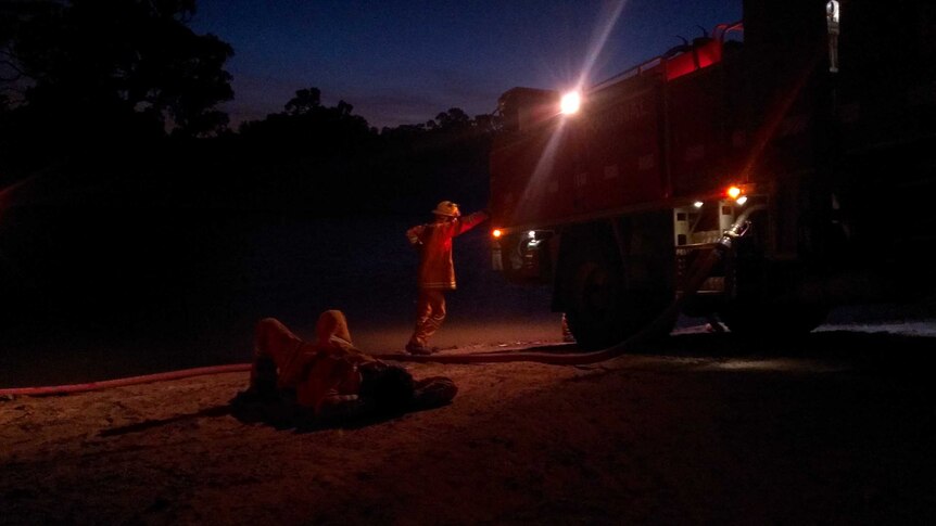 Firefighters take a break after controlling the Moyston fire on Friday night.
