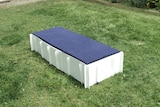 A disposable bed designed and built in Hobart sitting on a lawn.