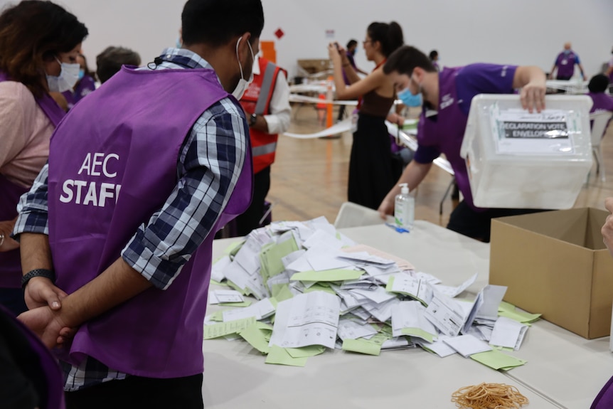 man looks over votes on table