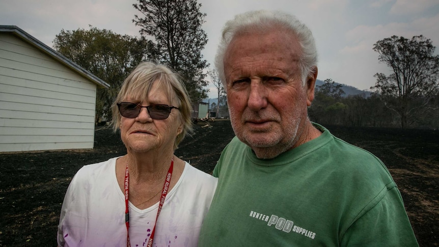 A couple standing in front of a house.