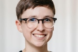 A portrait photo of Kate Clark, smiling, in front of a white background.