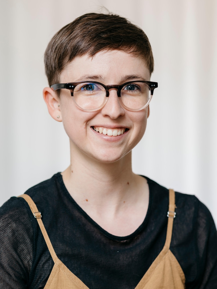 A portrait photo of Kate Clark, smiling, in front of a white background.