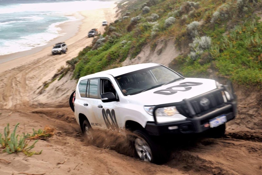 A Toyota Prado drives up a steep sand dune on Bornholm Beach.