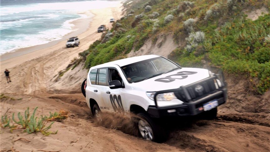 A Toyota Prado drives up a steep sand dune on Bornholm Beach.