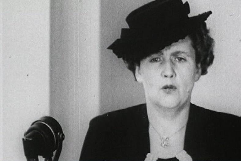 Old image of a woman in hat giving a speech