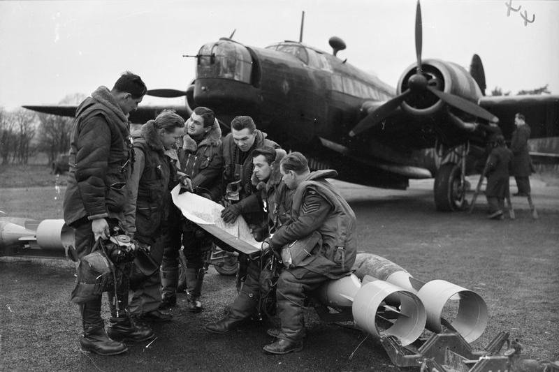 Airmen looking at map in front of large aircraft