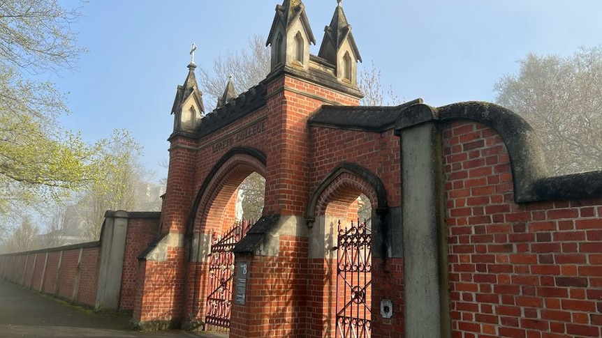 The red brick fence and iron gate of the college.