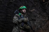 A soldier holding a gun in trenches