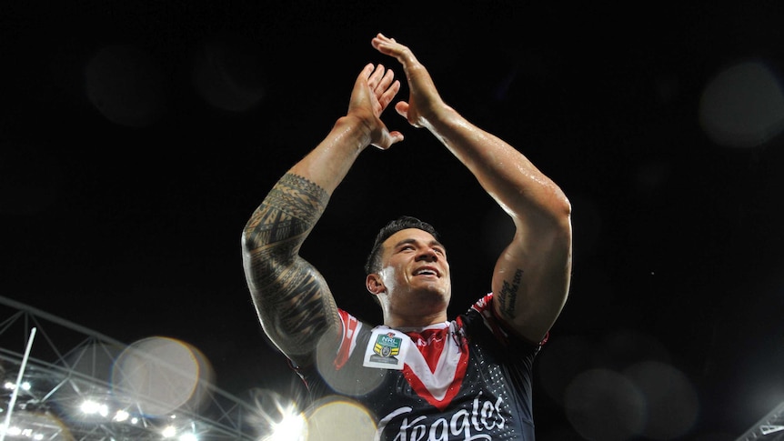 Sonny Bill Williams holds his hands above his head, acknowledging the crowd in the rain.