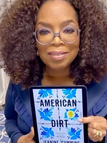 Oprah Winfrey holds a copy of the novel American Dirt on an iPad