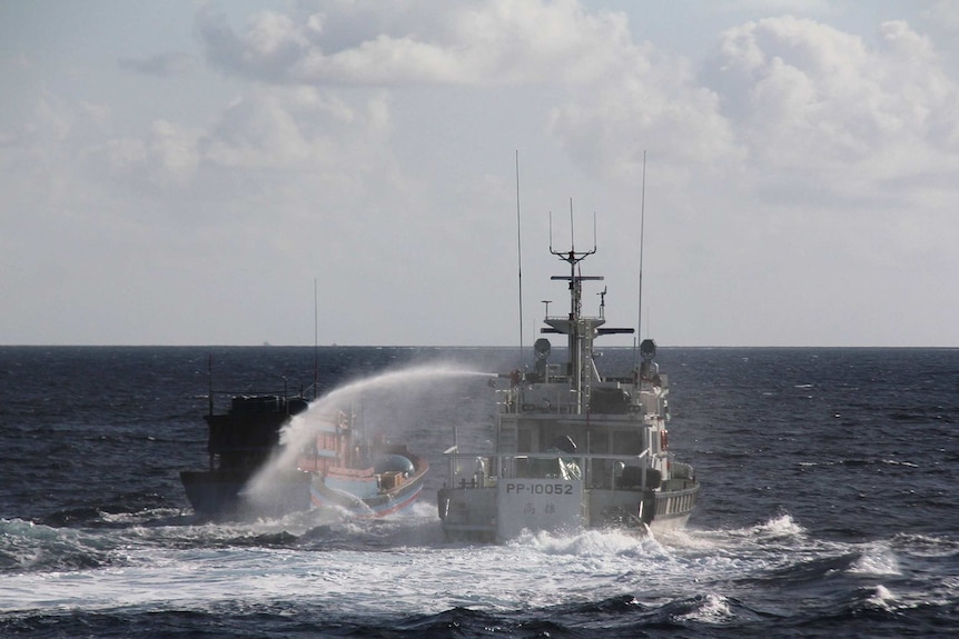 Taiwan's coastguard using a water cannon to spray a Vietnamese fishing boat