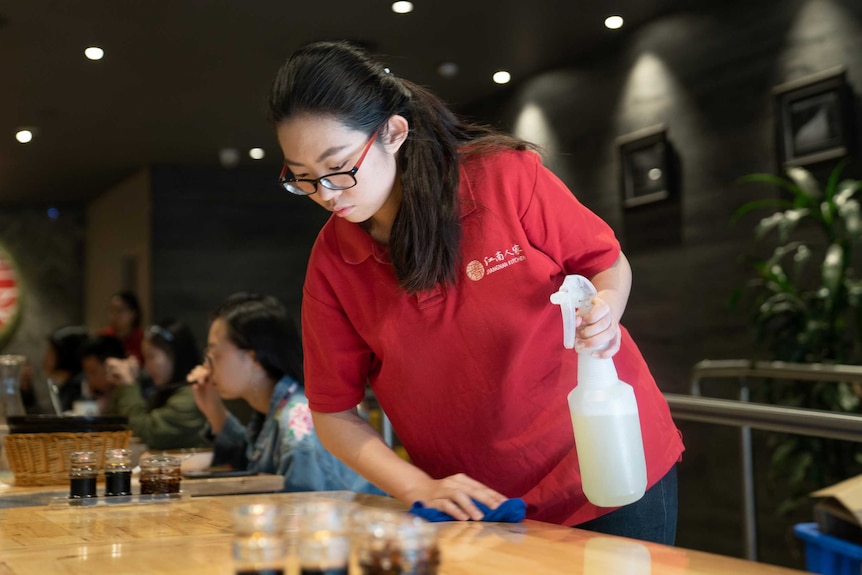 Abby Ran cleans tables at a restaurant in Sydney's Chinatown.