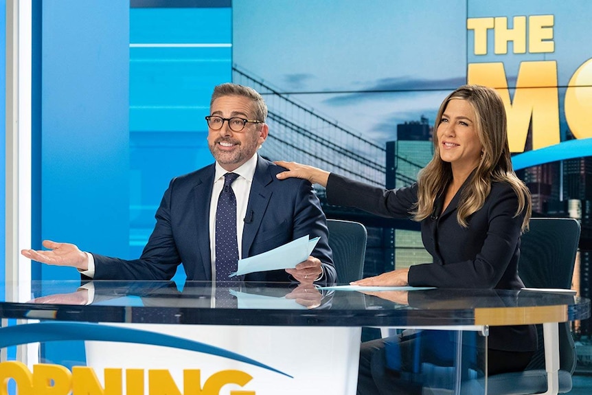 Jennifer and Steve sit at a news anchor's desk