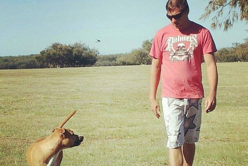 Anthony with his dog in a park.