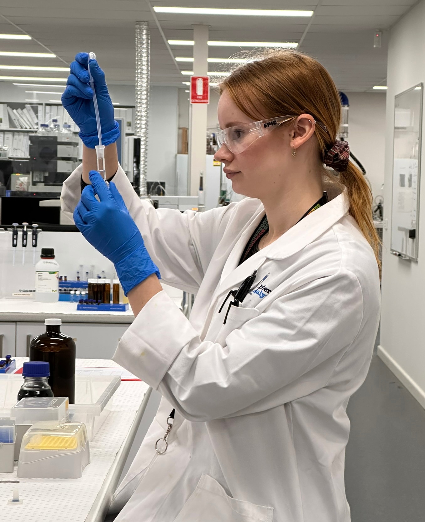 A chemist holds a test tube and dropper