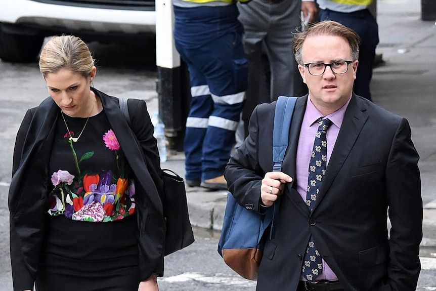 Jonathon Moran and a female arrive at court, walking across a pedestrian crossing