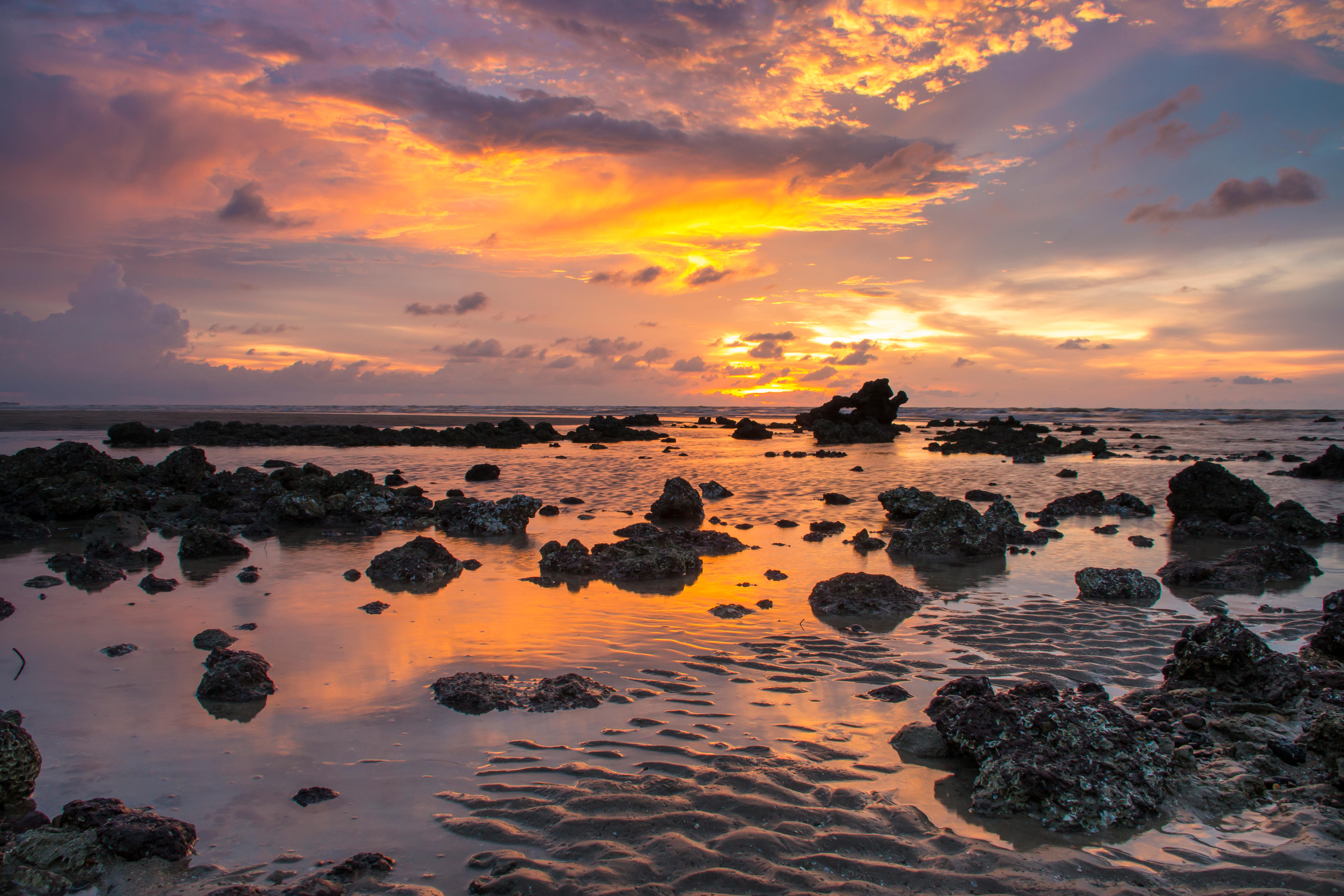 Una puesta de sol sobre una playa costera plana cerca de Darwin, NT.