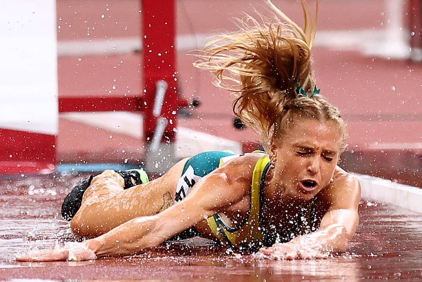 An Australian female athletes lies on the track after suffering an injury at the Tokyo Olympics.