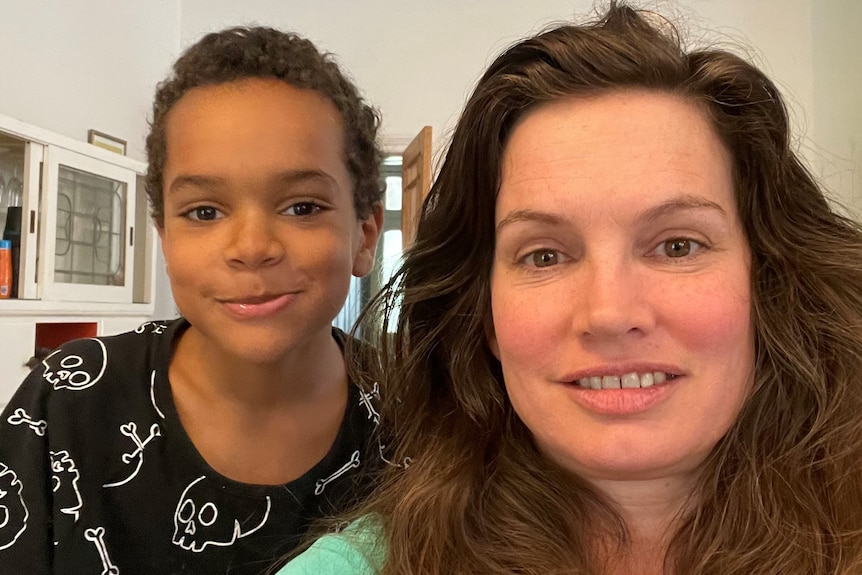 A close up shot of a mother and son smiling at the camera