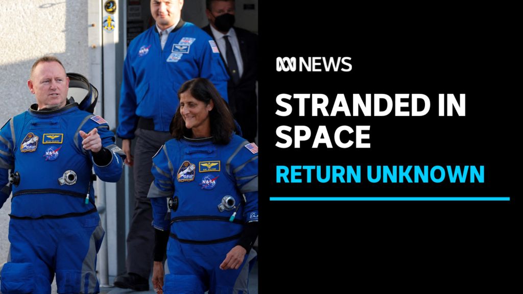 Stranded in Space, Return Unknown: Two astronauts in blue flightsuits walking. One points.