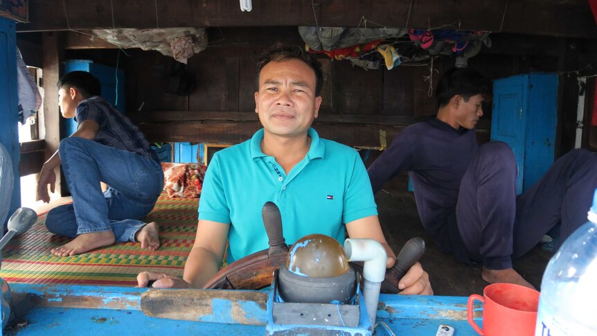 Captain Bui Ngoc Thanh stands at the helm of a fishing boat.