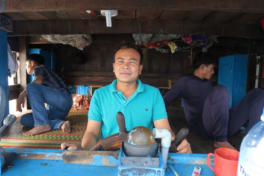 Captain Bui Ngoc Thanh stands at the helm of a fishing boat.